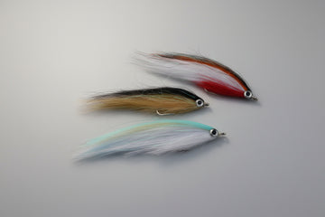 Two fishing lures on a dark brown surface