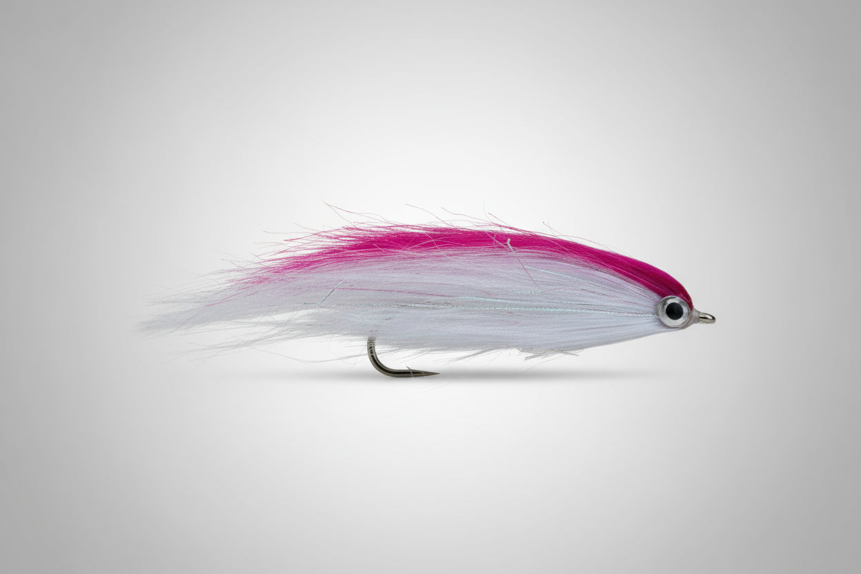Fishing lure with pink and white body on a dark background