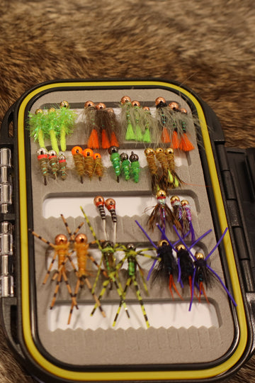 Fishing fly box with various flies on a fur background
